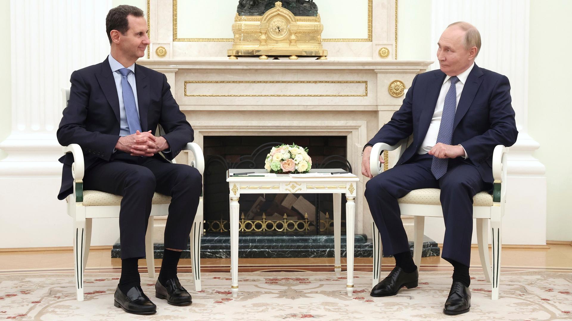 Moskau: Der syrische Präsident Baschar al-Assad (l) spricht mit dem russischen Präsidenten Wladimir Putin während ihres Treffens im Kreml. Sie sitzen sich an einem kleinen Tisch gegenüber.