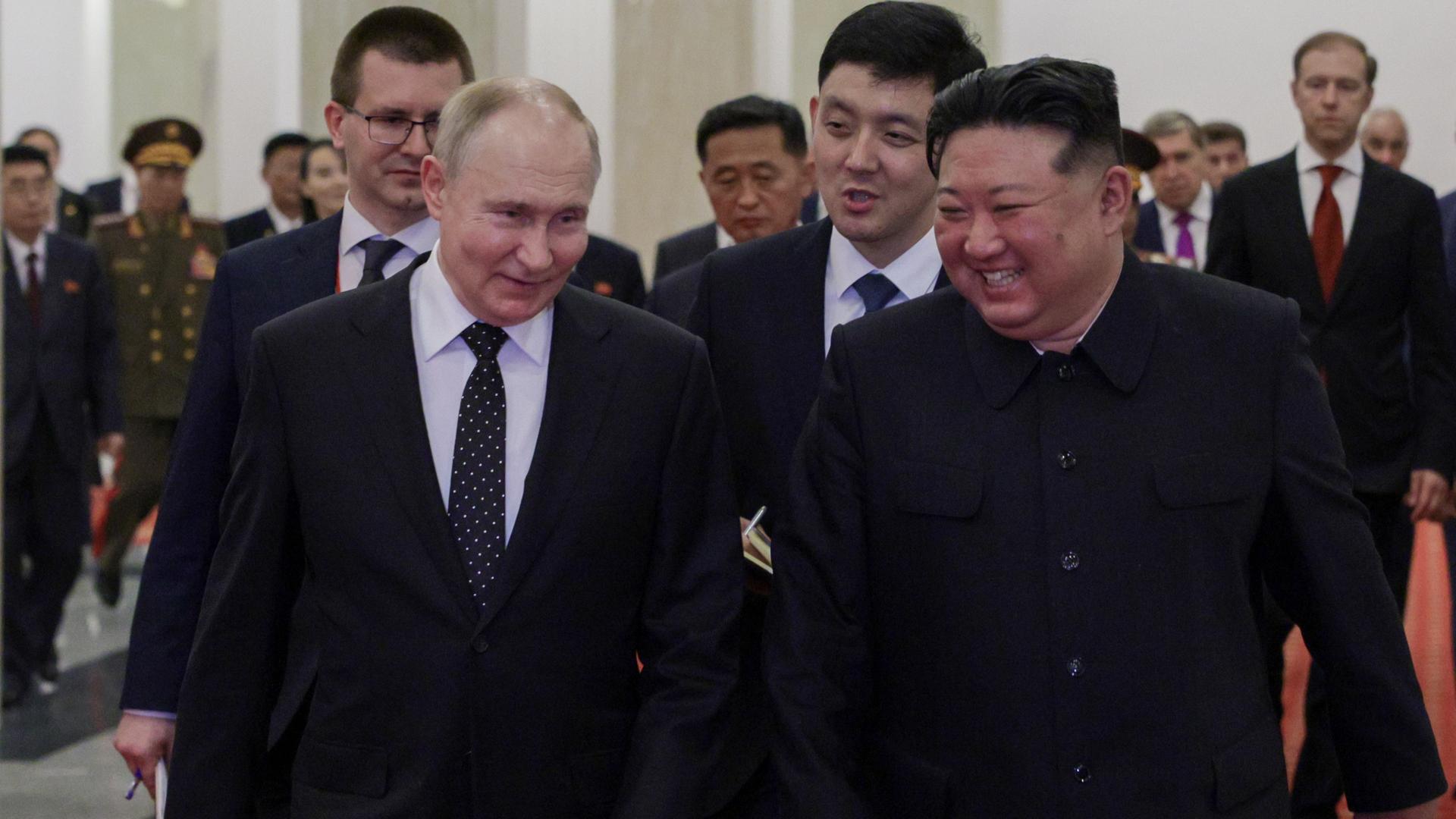 Vladimir Putin und Kim Jong-un bei einem Treffen - sie lächeln beide.
