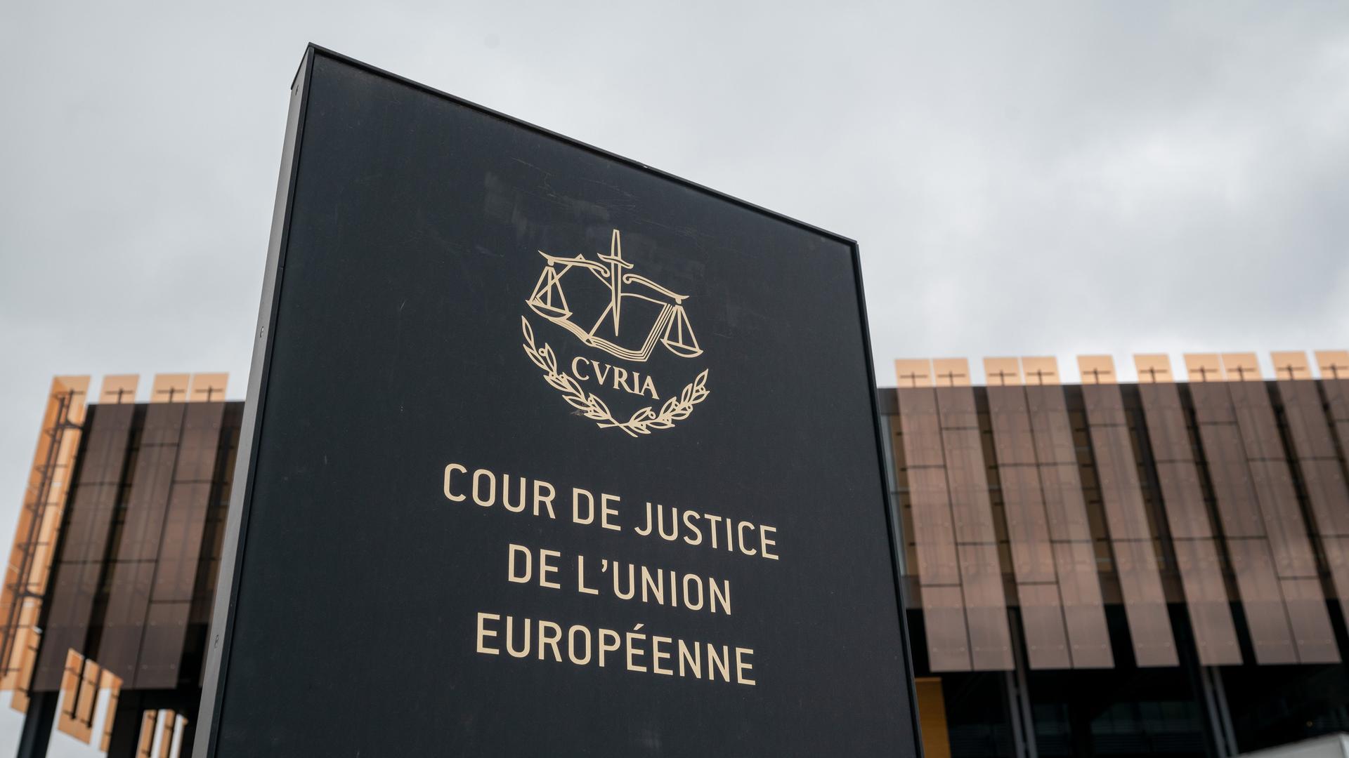 Das Foto zeigt ein Schild mit der Aufschrift "Cour de Justice de l'Union Europeene" vor einem Gebäude des Europäischen Gerichtshofs (EuGH) in Luxemburg