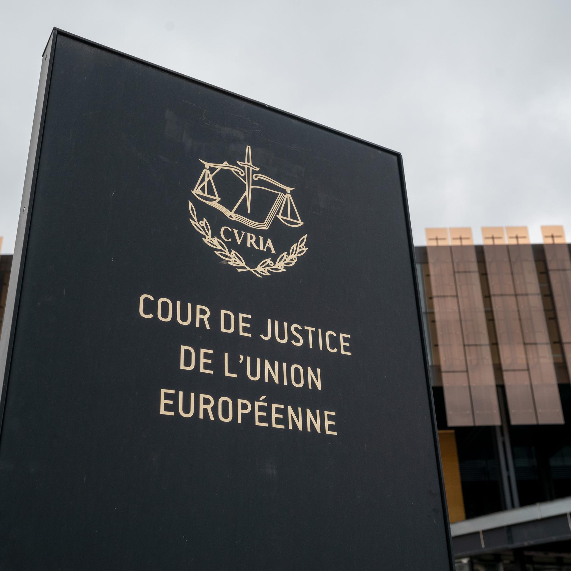 Das Foto zeigt ein Schild mit der Aufschrift "Cour de Justice de l'Union Europeene" vor einem Gebäude des Europäischen Gerichtshofs (EuGH) in Luxemburg