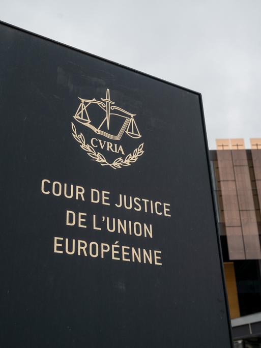 Das Foto zeigt ein Schild mit der Aufschrift "Cour de Justice de l'Union Europeene" vor einem Gebäude des Europäischen Gerichtshofs (EuGH) in Luxemburg