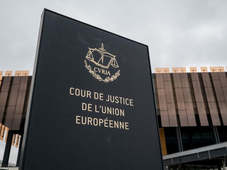 Das Foto zeigt ein Schild mit der Aufschrift "Cour de Justice de l'Union Europeene" vor einem Gebäude des Europäischen Gerichtshofs (EuGH) in Luxemburg