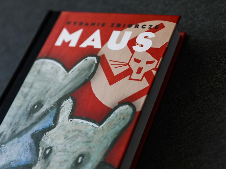 Foto des Covers der Graphic Novel "Maus". Darauf zu sehen sind zwei graue Mäuseköpfe, Nazi-Symbole und ein stilisierter Hitlerkopf, der an eine Katze erinnert.