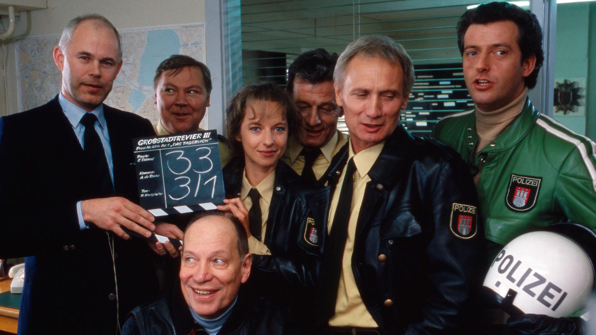 Auf dem Foto ist eine Gruppe von Menschen zu sehen, darunter der verstorbene Schauspieler Arthur Brauss. Das Foto stamm aus dem Jahr 1986 und zeigt eine Szene aus der ARD-Fernsehserie "Großstadtrevier". Auf dem Foto ist eine Gruppe von Menschen zu sehen, darunter der verstorbene Schauspieler Arthur Brauss. Das Foto stamm aus dem Jahr 1986 und zeigt eine Szene aus der ARD-Fernsehserie "Großstadtrevier".