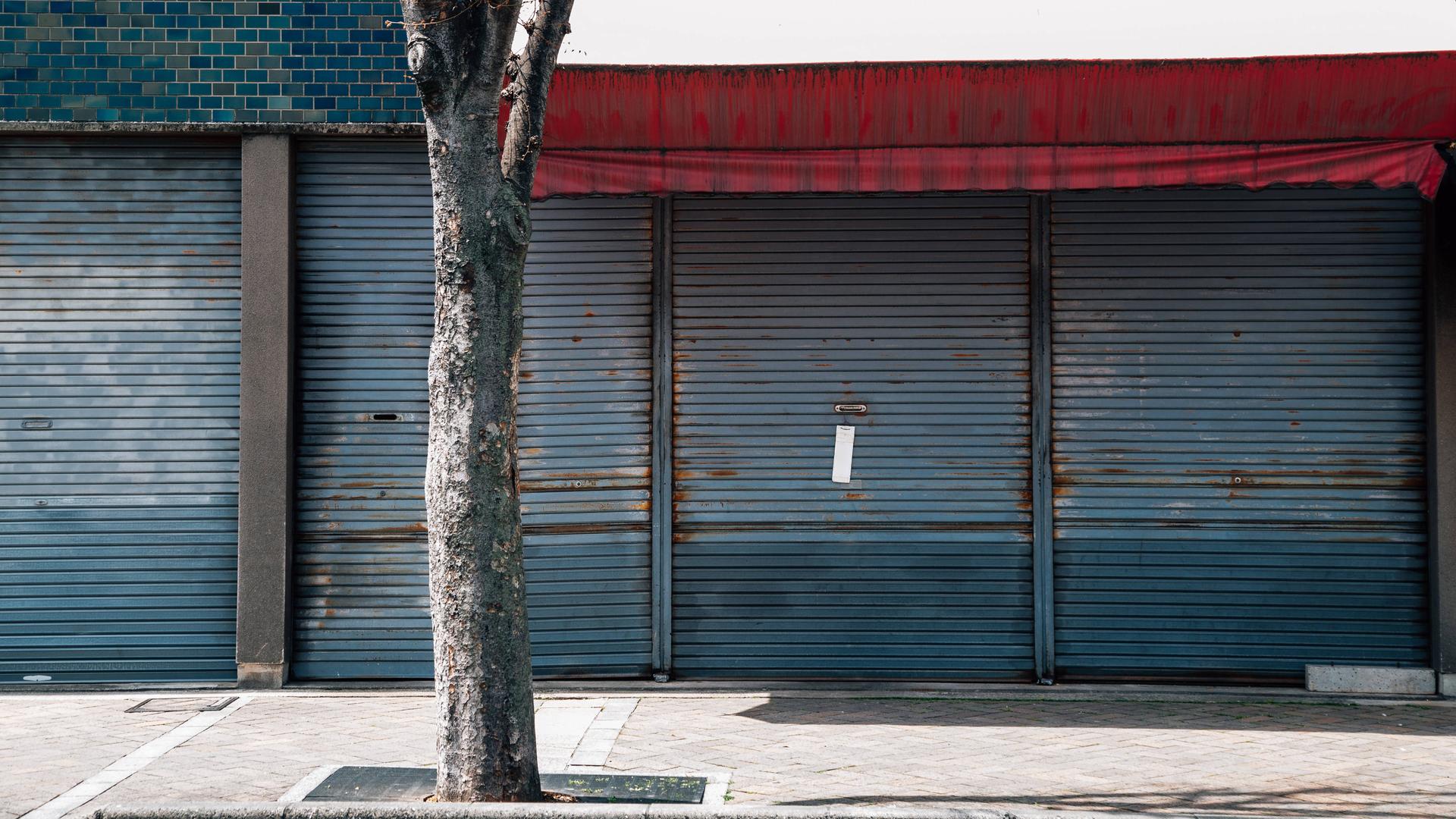 Außenansicht eines Gebäudes in Japan. Ein Metallgitter ist heruntergelassen. Das Gebäude sind verlassen aus. 