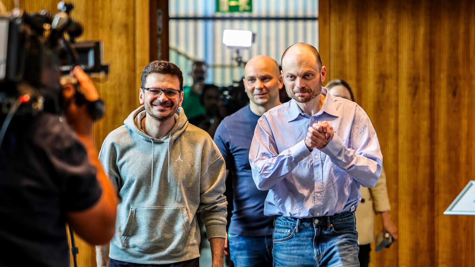 Ilja Jaschin (von links nach rechts), Andrej Piwowarow, Wladimir Kara-Mursa kommen zur Pressekonferenz in Bonn und gehen durch eine Tür. Links im Bild ein Kameramann. 