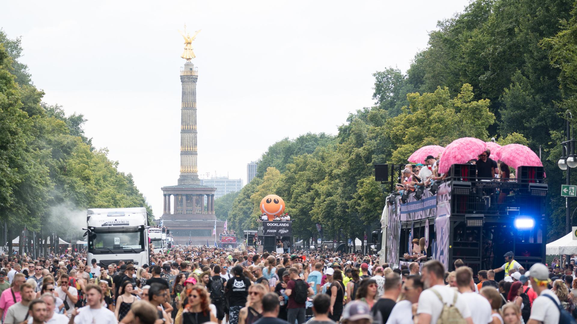 Feiernde Menschen und fahrende Wagen während der Technoparade "Rave The Planet", die unter dem Motto «Love is stronger» stattfand, auf der Straße des 17. Juni in Berlin. 