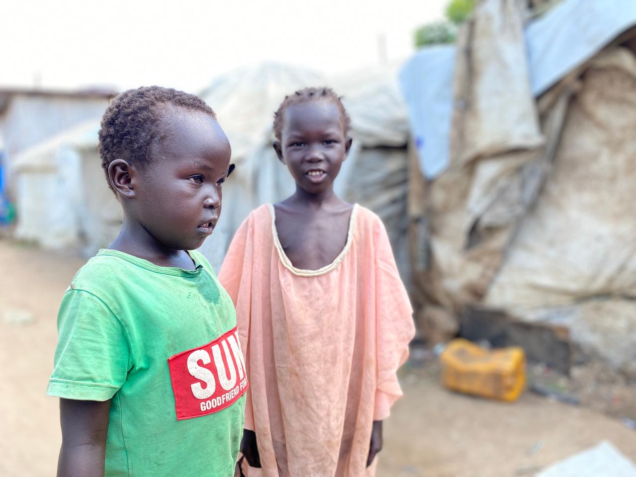 Zwei Kinder in alten, übergroßen T-Shirts in einem Lager für Vertriebene am Rande von Juba.