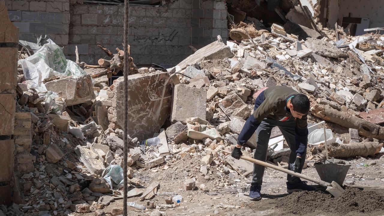 Ein iranischer Freiwilliger räumt Schutt in einem zerstörten Gebäude in der Stadt Karaj weg. 
