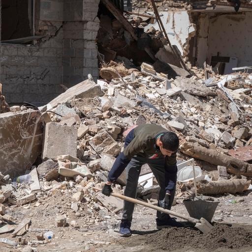 Ein iranischer Freiwilliger räumt Schutt in einem zerstörten Gebäude in der Stadt Karaj weg. 