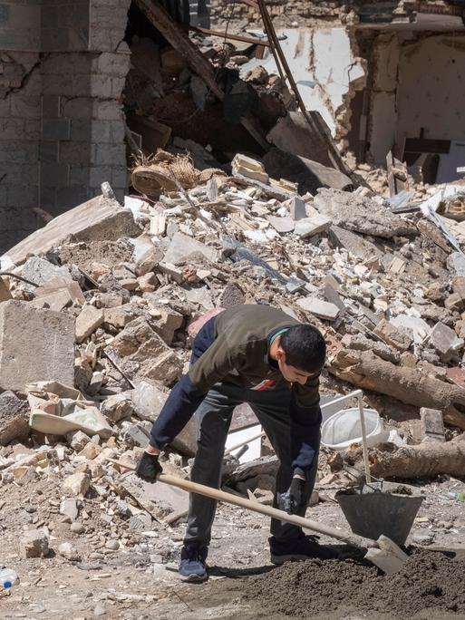 Ein iranischer Freiwilliger räumt Schutt in einem zerstörten Gebäude in der Stadt Karaj weg. Ein iranischer Freiwilliger räumt Schutt in einem zerstörten Gebäude in der Stadt Karaj weg.
