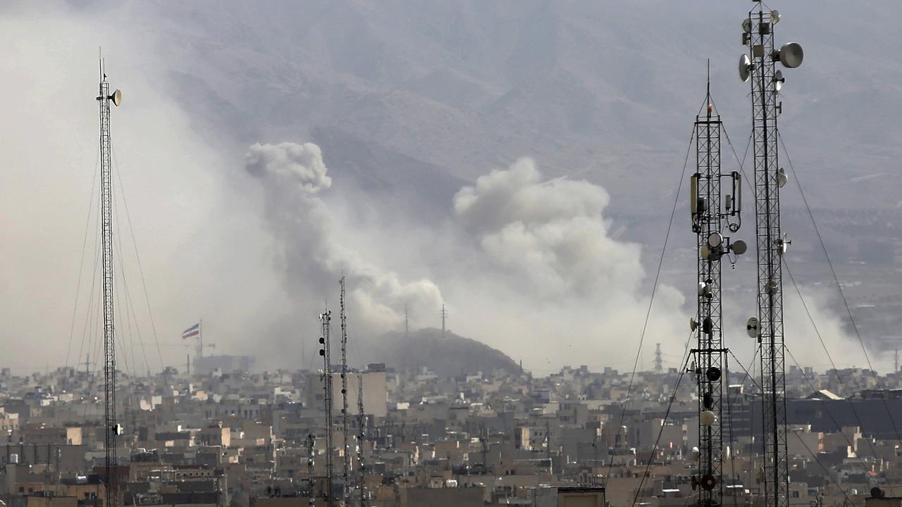 Über den Dächern von Teheran steigen Rauchwolken auf, im Vordergrund sind Sendemasten zu sehen.