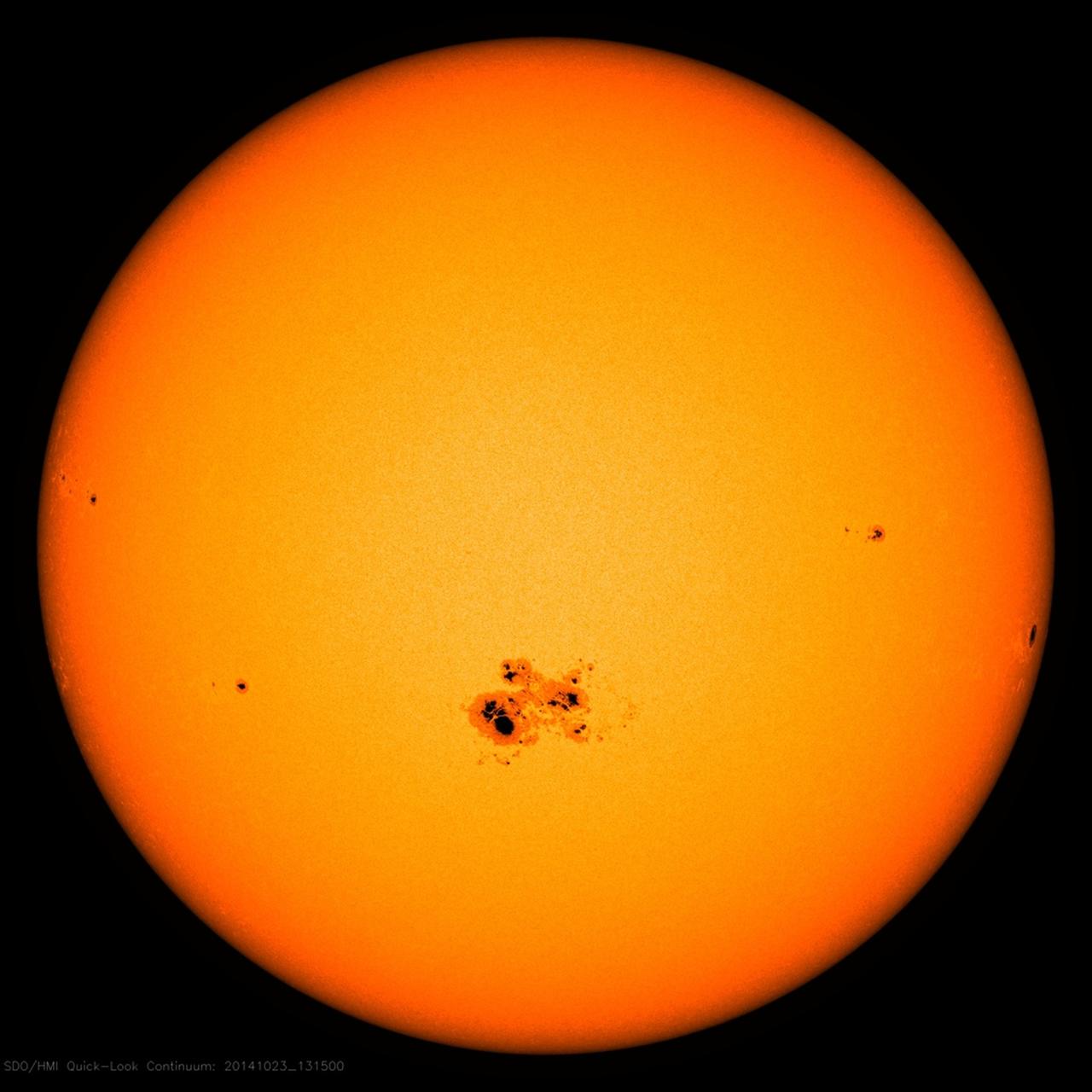 Die Sonne ist zu sehen, auf ihr sind kleine schwarze Flecken.