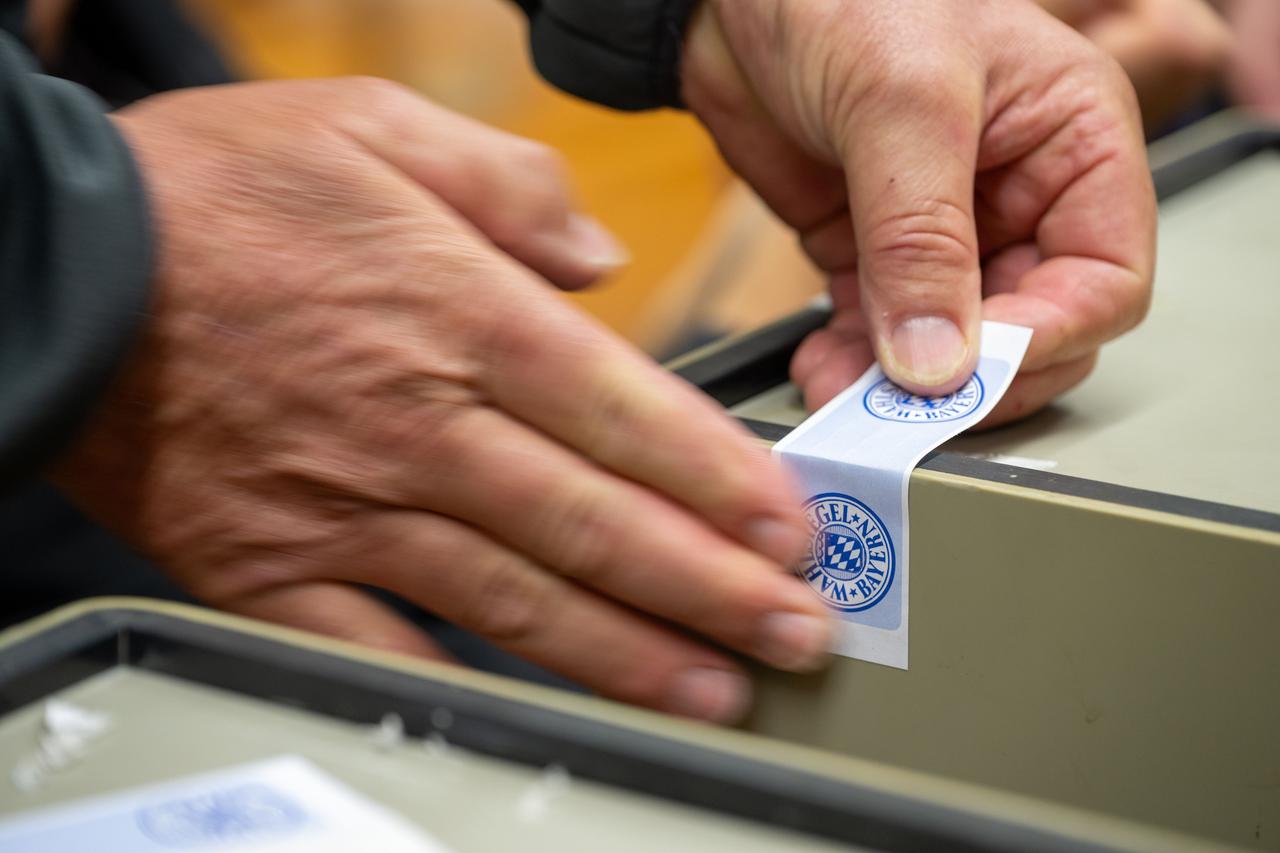 Eine Wahlurne wird mit einem Wahlsiegel des Freistaats Bayern versiegelt. 