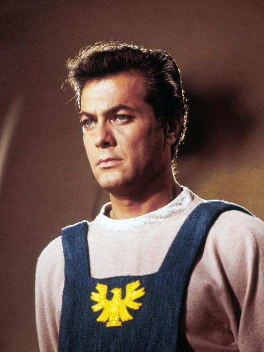 Tony Curtis als Andrei Bulba in dem Film Taras Bulba, der 1962 erschien. Er blickt mit ernster Miene aus dem Bild heraus.