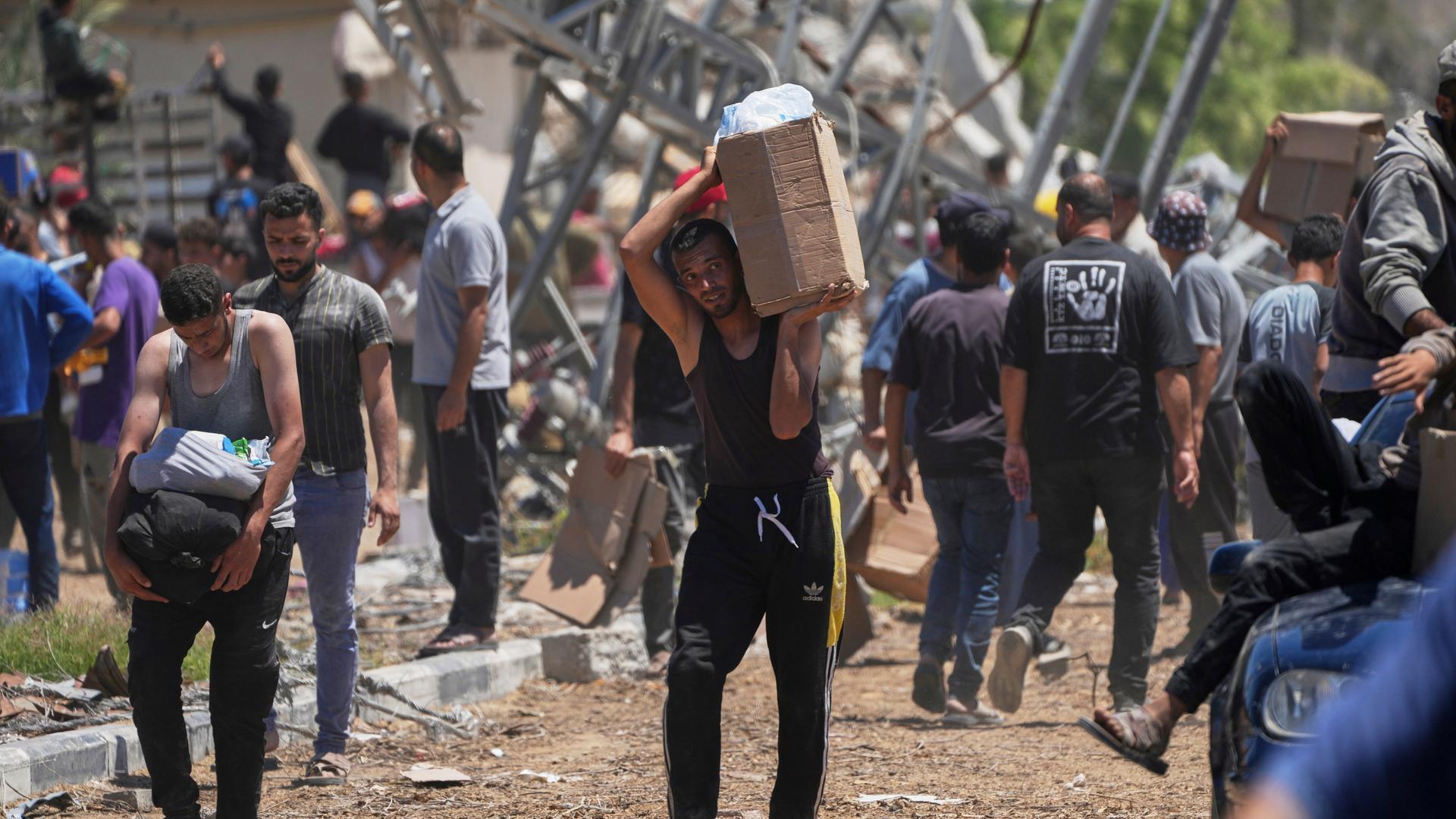 Rafah: Palästinenser tragen Kisten und Taschen mit Lebensmitteln und humanitären Hilfspaketen, die von der Gaza Humanitarian Foundation, einer von Israel anerkannten und von den USA unterstützten Organisation geliefert wurden.