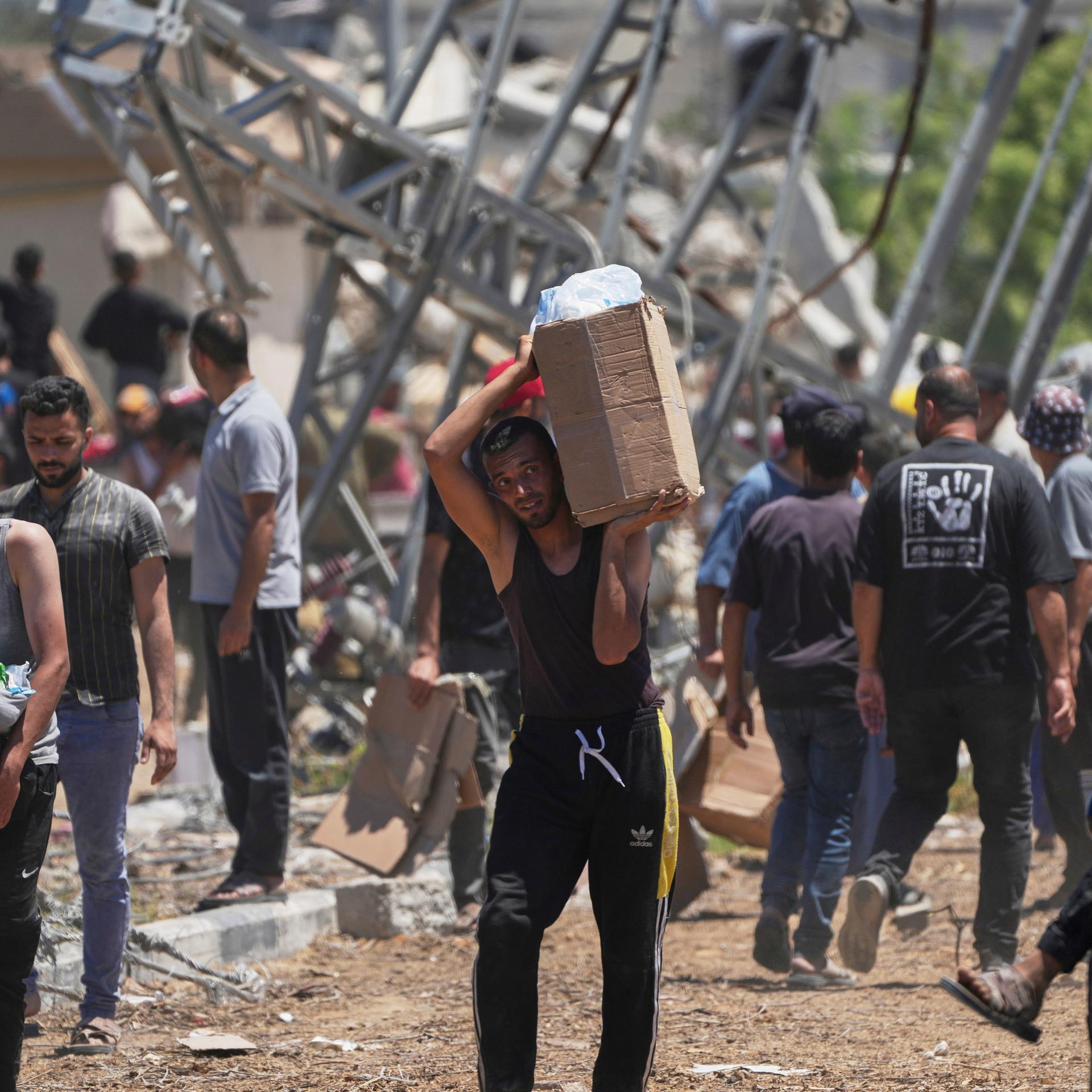 Rafah: Palästinenser tragen Kisten und Taschen mit Lebensmitteln und humanitären Hilfspaketen, die von der Gaza Humanitarian Foundation, einer von Israel anerkannten und von den USA unterstützten Organisation geliefert wurden.