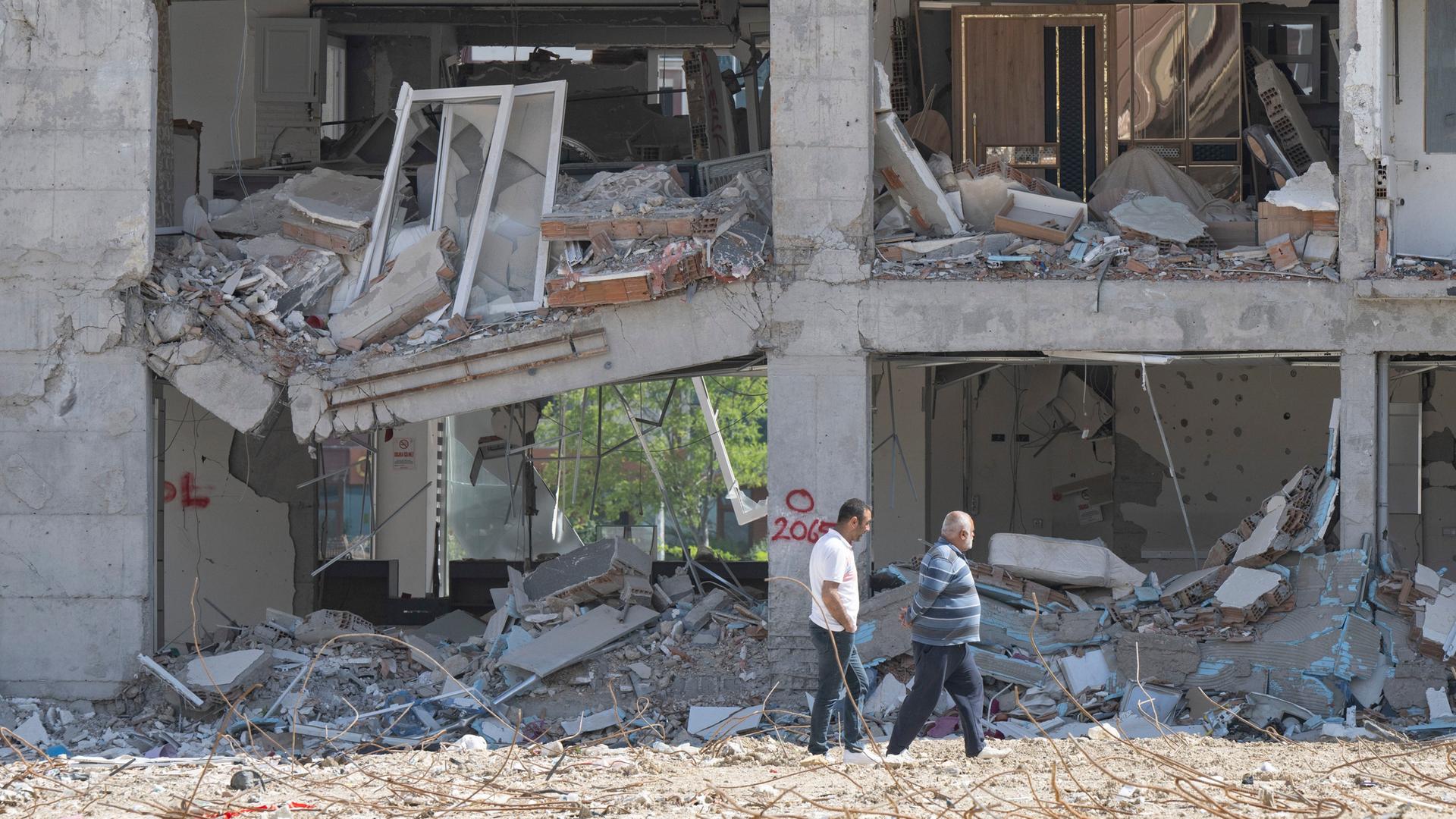 Anwohner gehen an einer zerstörten Häuserzeile entlang. Weite Teile der Stadt wurden bei dem Erdbeben vom sechsten Februar komplett zerstört.