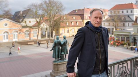 Ein Mann mittleren Alters steht am 07.03.2017 auf dem Balkong des Deutschen Nationaltheater in Weimar (Thüringen), im Hintergrund ein Denkmal von Goethe und Schiller