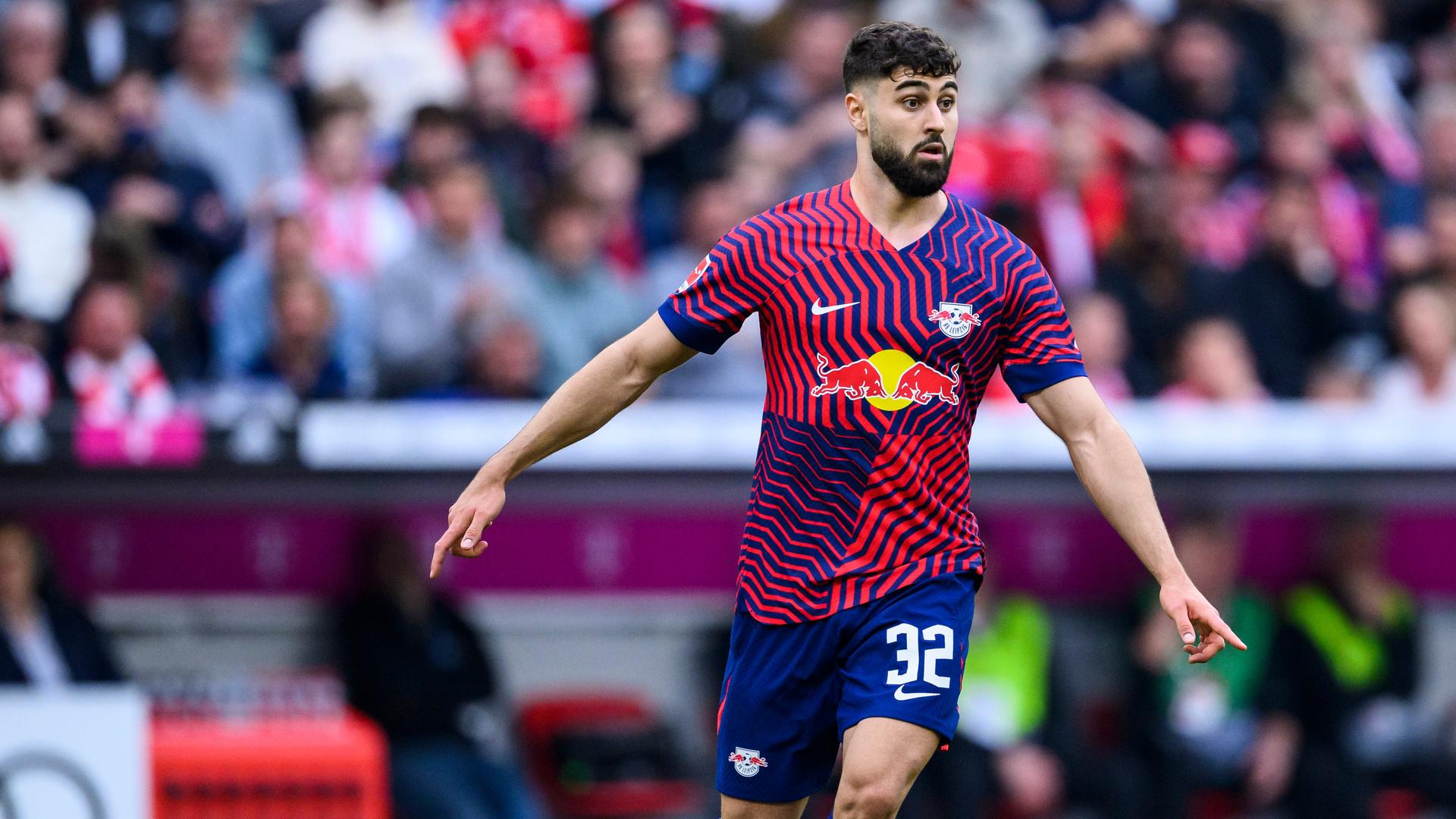 Ein Fußballspieler in einem blau-pinkfarbenen Trikot läuft über das Spielfeld. Ein Fußballspieler in einem blau-pinkfarbenen Trikot läuft über das Spielfeld.