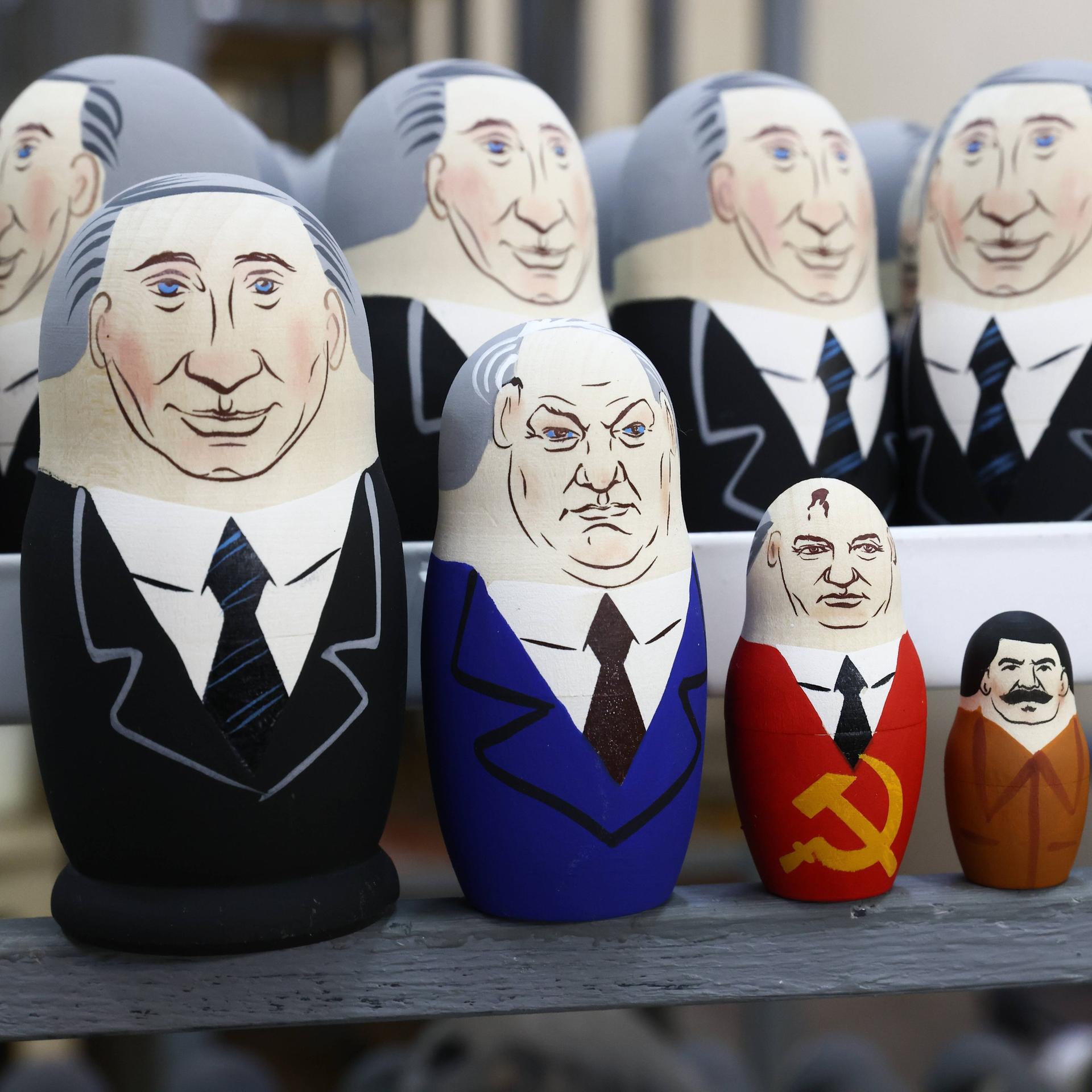 Putin als Matrjoschka, mit Figuren von Jelzin, Gorbatschow, Stalin und Lenin.