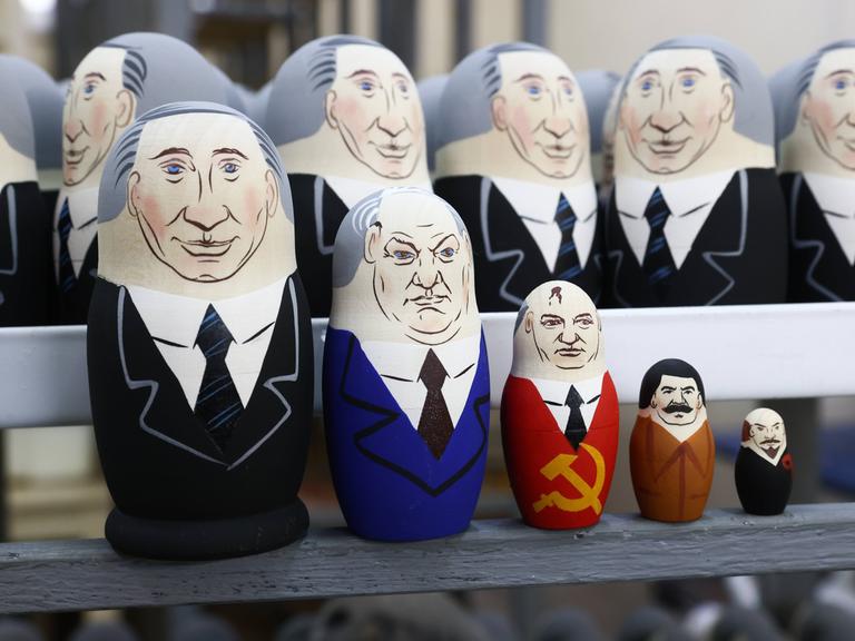 Putin als Matrjoschka, mit Figuren von Jelzin, Gorbatschow, Stalin und Lenin als Matrjoschka-Puppen.