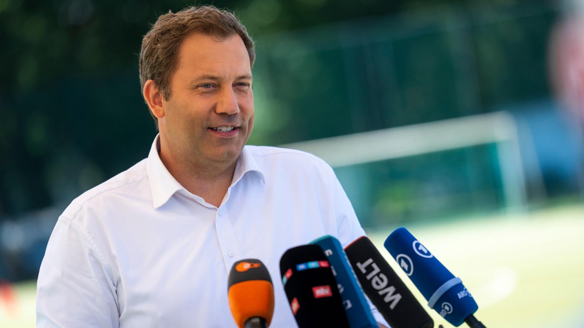 Lars Klingbeil spricht in mehrere Mikrofone. 