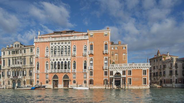 Ein Haus mit mehreren Stock-Werken steht an einem Kanal in Venedig.
