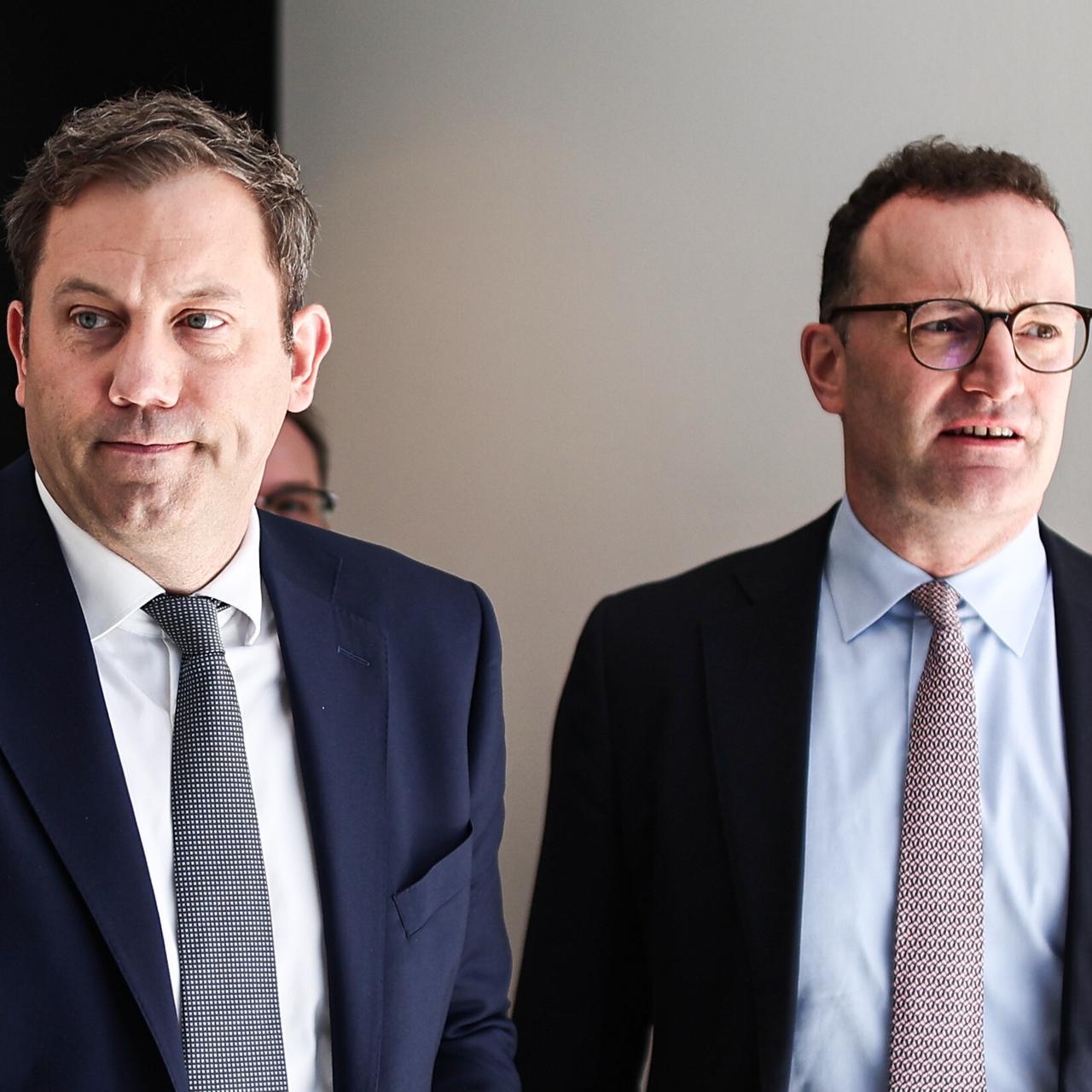 Lars Klingbeil (li.) und Jens Spahn (CDU) verlassen nebeneinander einen Raum im Bundestag.