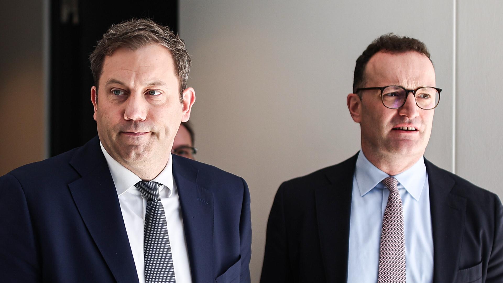 Lars Klingbeil (li.) und Jens Spahn (CDU) verlassen nebeneinander einen Raum im Bundestag.