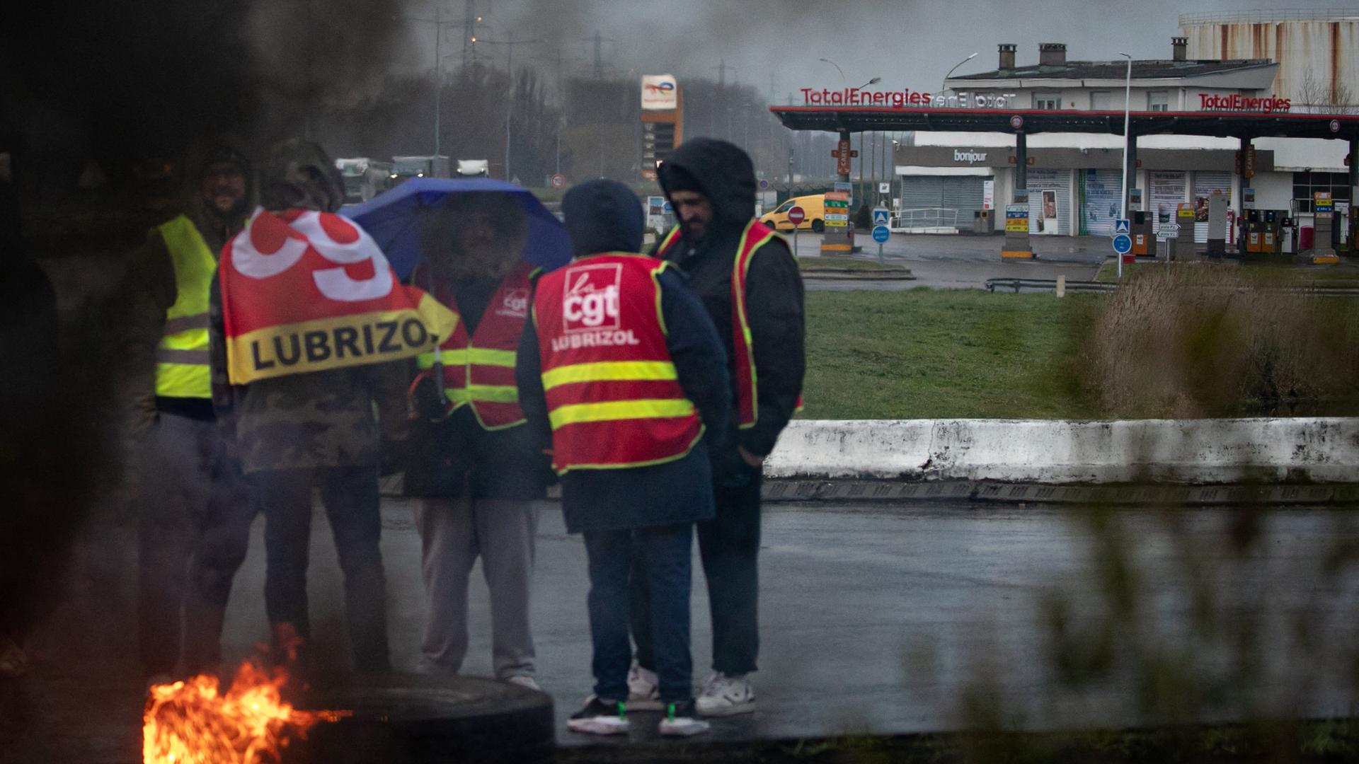Demonstranten in Warnwesten stehen versammelt vor einer Tankstelle von Total Energies. Demonstranten in Warnwesten stehen versammelt vor einer Tankstelle von Total Energies.