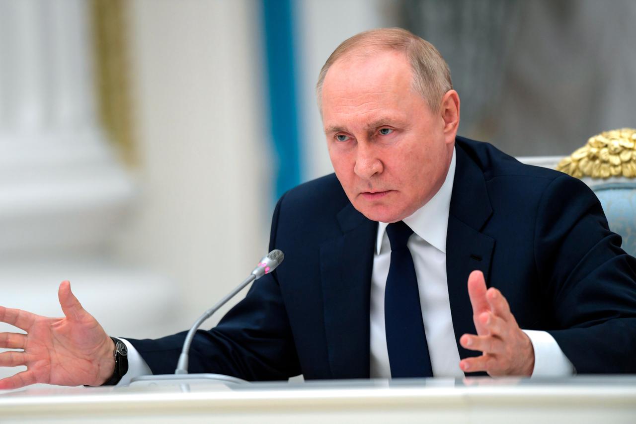 Russlands Präsident Wladimir Putin spricht in eine Mikrofon.