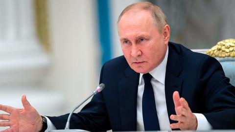 Russlands Präsident Wladimir Putin spricht in ein Mikrofon.