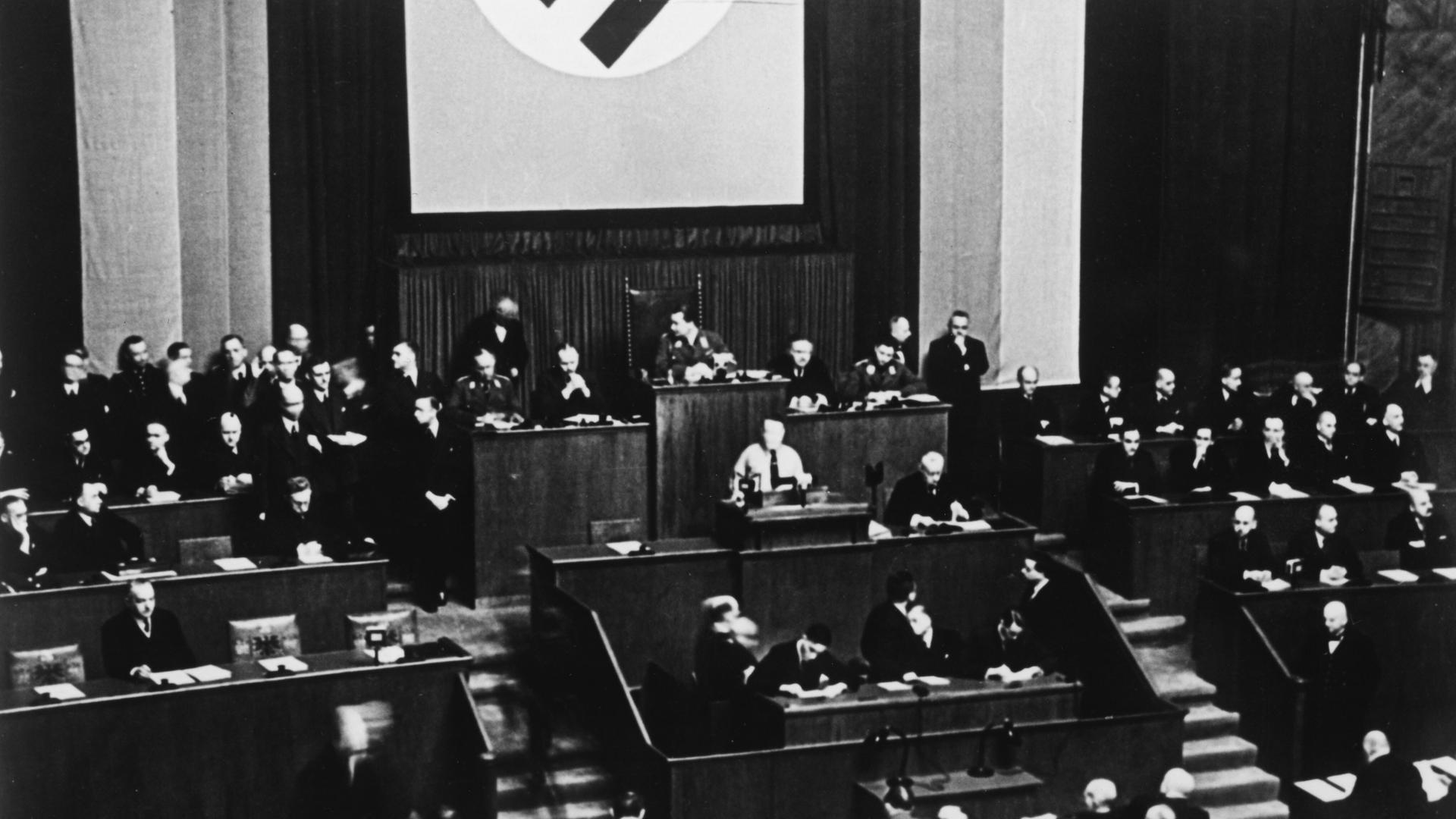 Das Schwarzweißbild zeigt Adolf Hitlers am Rednerpult des Reichstags unter der Hakenkreuzflagge am 23. März 1933 vor der Abstimmung über das "Gesetz zur Behebung der Not von Volk und Reich".Das sogenannte "Ermächtigungsgesetz"
