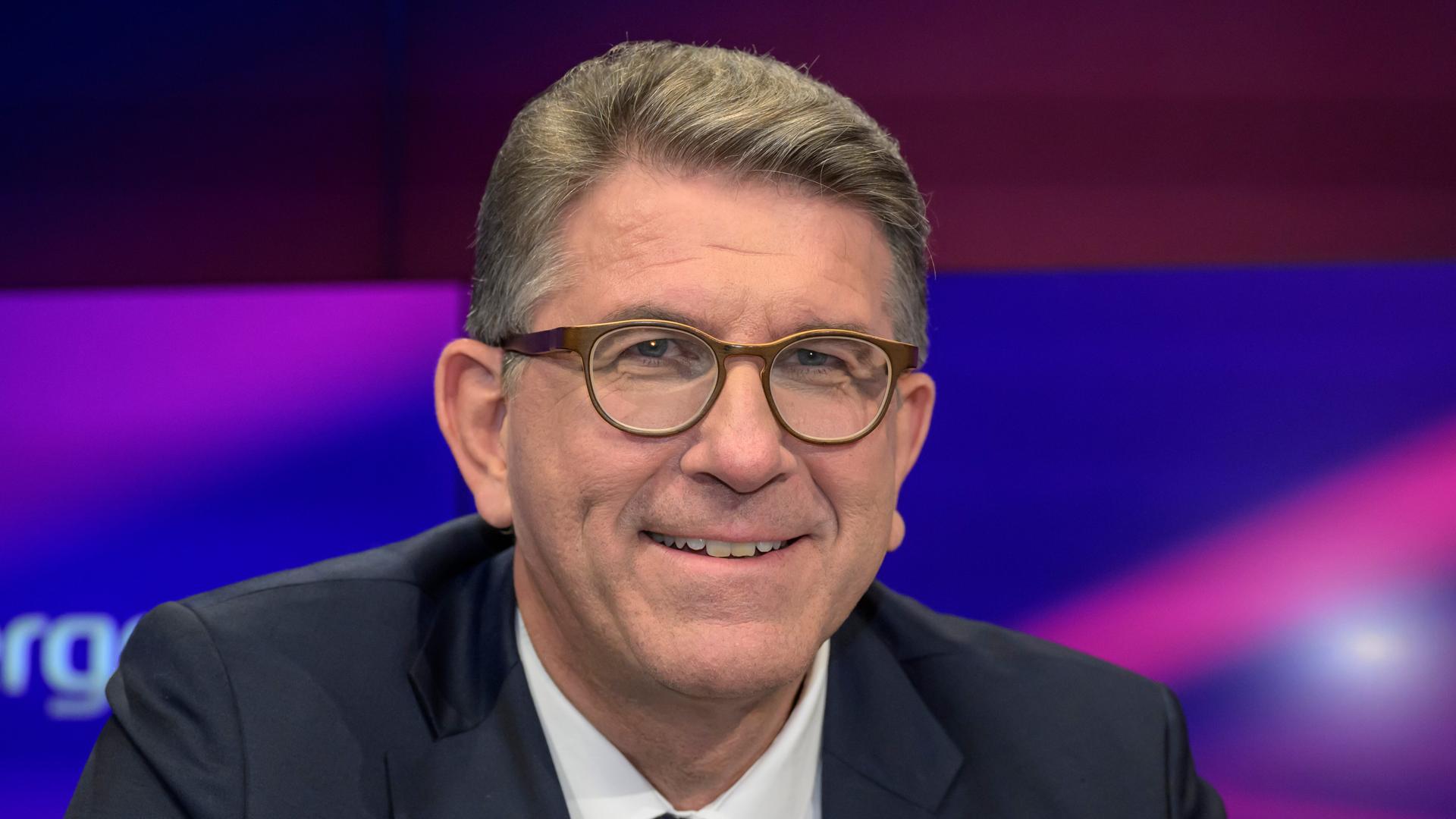 Porträt von Wolfram Weimer in einem Fernsehstudio. Er trägt Brille und lacht.