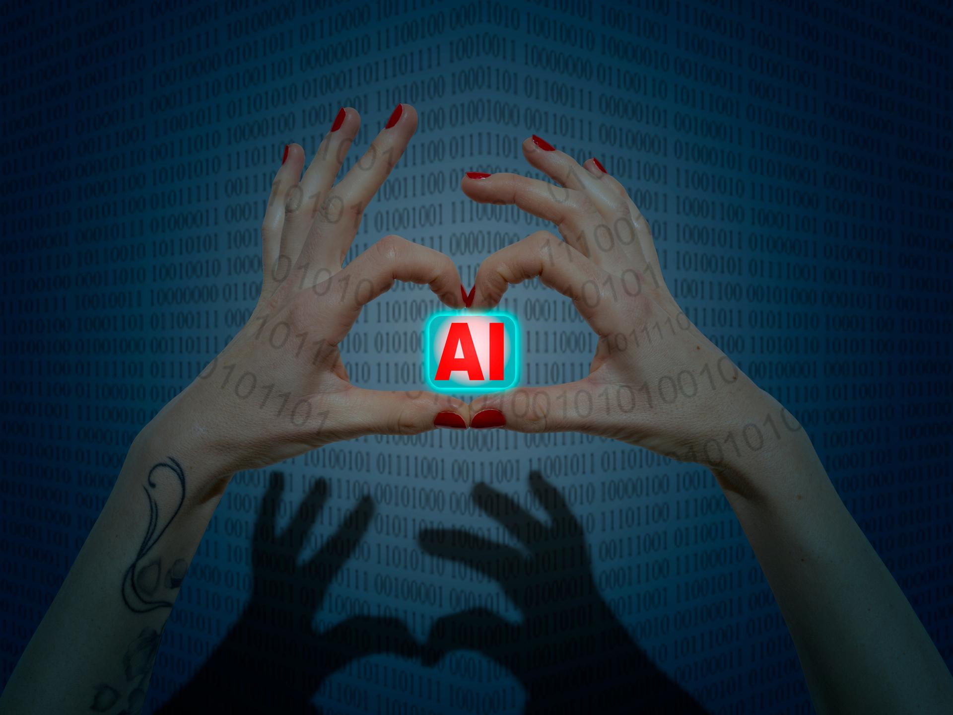 Zwei Hände mit rot lackierten Finger bilden eine Herzform in der sie ein Symbol mit dem Schriftzug AI (Artificial Intelligence) halten.