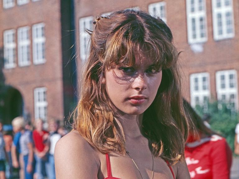 Die 15 jährige Nastassja Kinski bei den Dreharbeiten zum Tatort "Reifezeugnis" in einem Sommerkleid auf einem Schulhof.