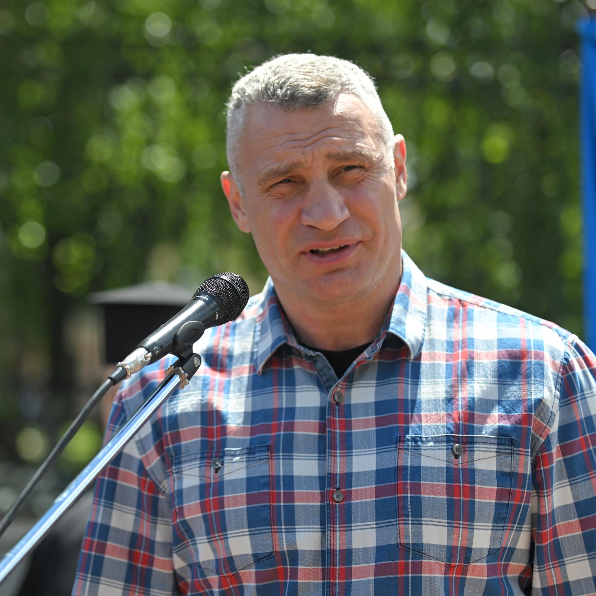 Der Bürgermeister der ukrainischen Hauptstadt Kiew, Vitali Klitschko, spricht in ein Mikrofon. Er trägt ein kariertes Hemd.