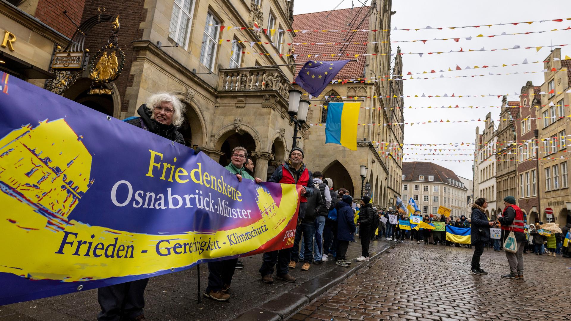 In Münster demonstrieren Menschen vor dem Rathaus gegen den Krieg in der Ukraine und bilden dabei einen Teil einer Menschenkette vom Friedenssaal Münster zum Friedenssaal Osnabrück. In Münster demonstrieren Menschen vor dem Rathaus gegen den Krieg in der Ukraine und bilden dabei einen Teil einer Menschenkette vom Friedenssaal Münster zum Friedenssaal Osnabrück.