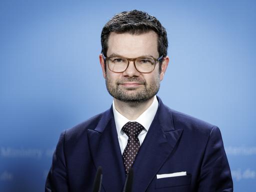 Porträt von Marco Buschmann. Der Minister trägt Anzug, Brille und Drei-Tage-Bart.