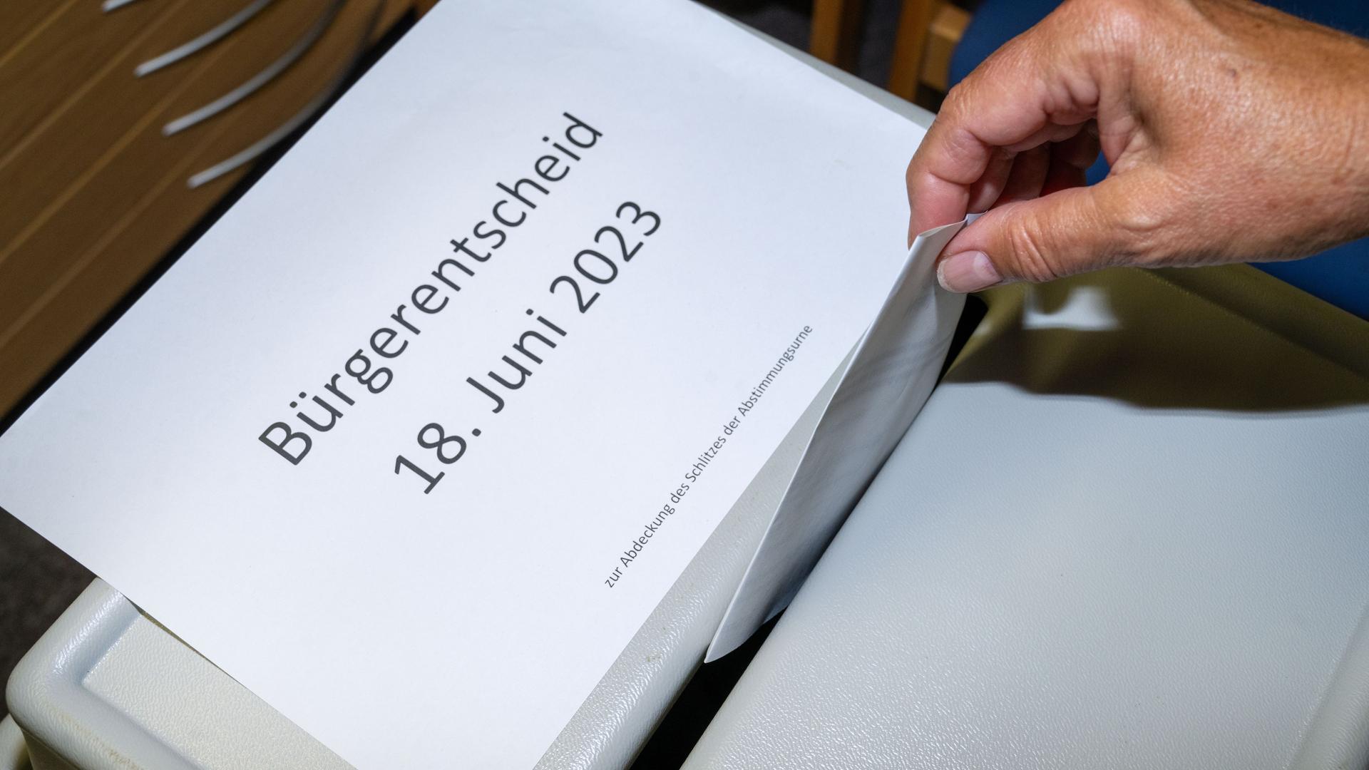 Greifswald: Ein Stimmzettel zum Bürgerentscheid wird in einem Abstimmungslokal in die Wahlurne eingeworfen. Darf Greifswald dem Landkreis städtische Flächen für Containerunterkünfte für Geflüchtete verpachten? Greifswald: Ein Stimmzettel zum Bürgerentscheid wird in einem Abstimmungslokal in die Wahlurne eingeworfen. Darf Greifswald dem Landkreis städtische Flächen für Containerunterkünfte für Geflüchtete verpachten?