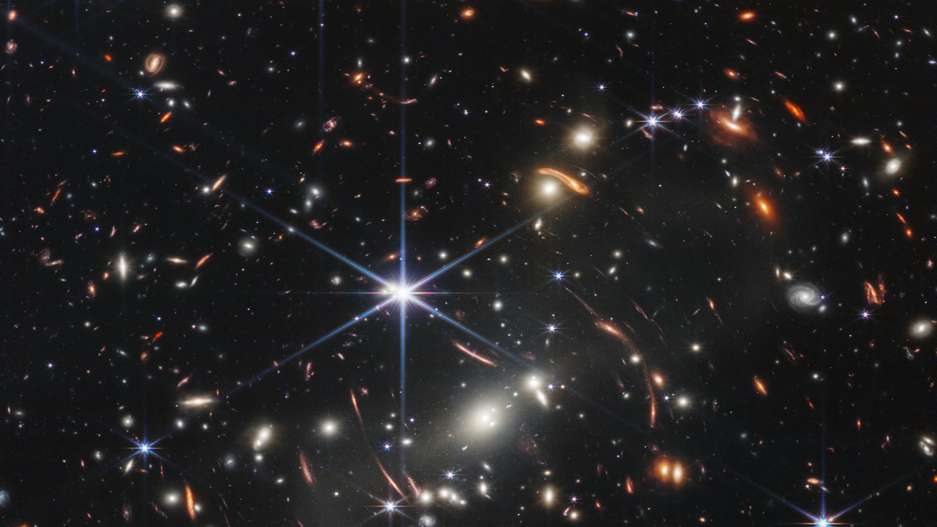 Eine der ersten im Juli 2022 veröffentlichten Infrarot-Aufnahmen des James-Webb-Weltraumteleskops zeigt grell leuchtende Punkte und Sterne, bei denen es sich um Galaxie-Haufen handelt.
