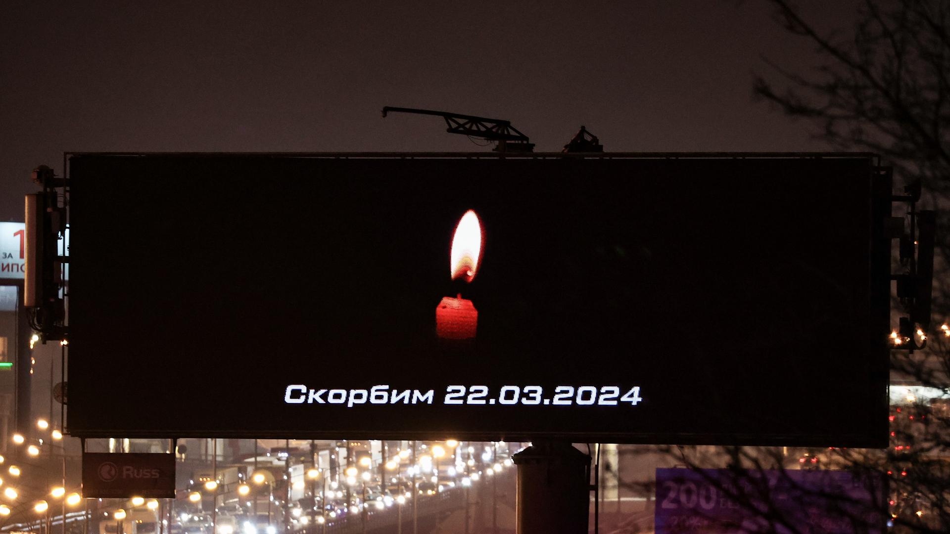 Eine Kerze und der Satz "Wir trauern" auf einer Bildtafel  erinnert an die Toten und Verletzten des Anschlags in einer Konzerthalle bei Moskau. 