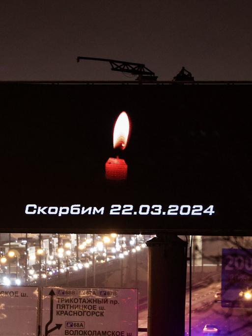 Eine Kerze und der Satz "Wir trauern" auf einer Bildtafel  erinnert an die Toten und Verletzten des Anschlags in einer Konzerthalle bei Moskau. 
