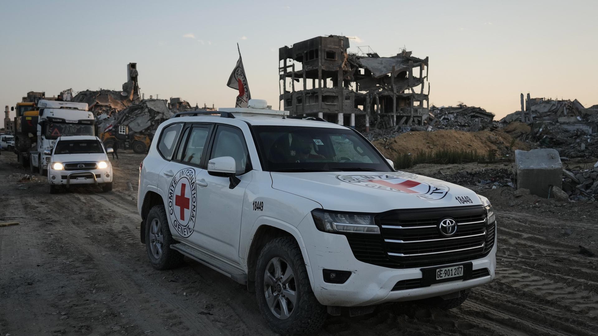 Ein Geländewagen des Roten Kreuzes fährt durch die Ruinenlandschaft des Gazastreifens.