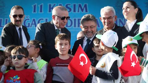 Der türkische Präsident Recep Tayyip Erdoğan ist von Kindern umgeben, einige von ihnen haben türkische Fähnchen in der Hand. Der türkische Präsident Recep Tayyip Erdoğan ist von Kindern umgeben, einige von ihnen haben türkische Fähnchen in der Hand.
