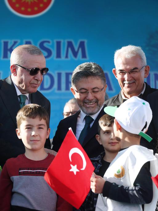 Der türkische Präsident Recep Tayyip Erdoğan ist von Kindern umgeben, einige von ihnen haben türkische Fähnchen in der Hand.
