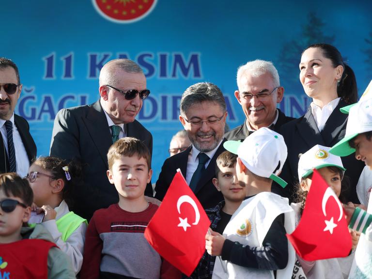 Der türkische Präsident Recep Tayyip Erdoğan ist von Kindern umgeben, einige von ihnen haben türkische Fähnchen in der Hand.