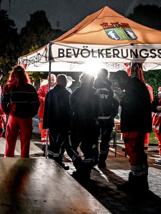 Mitarbeiter des Deutschen Roten Kreuzes (DRK) und des Technischen Hilfswerks (THW) stehen am 09.09.2025 an einer Anlaufstelle für die Bevölkerung beim Stromausfall in Adlershof. 