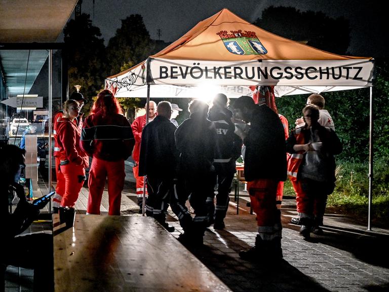 Mitarbeiter des Deutschen Roten Kreuzes (DRK) und des Technischen Hilfswerks (THW) stehen am 09.09.2025 an einer Anlaufstelle für die Bevölkerung beim Stromausfall in Adlershof. 